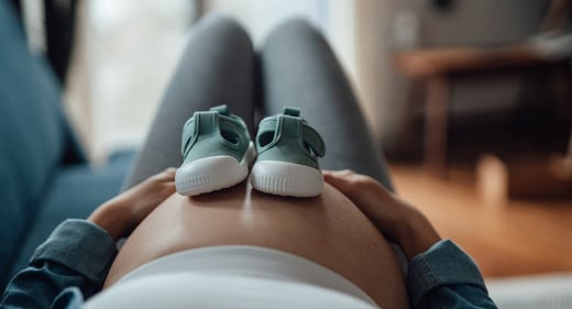 GettyImages-1390469990-baby-shoes-pregnant-1